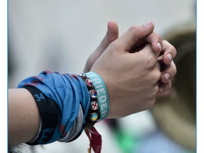 Hände eines jungen Menschen zusammengelegt; Freundschaftsbänder "Frieden"